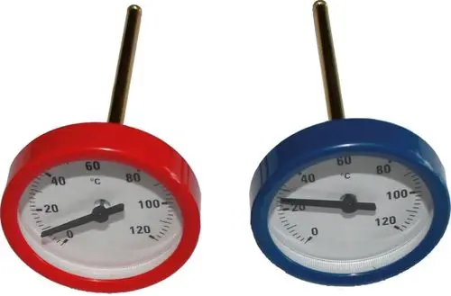 Zwei Thermometer von Wolf mit unterschiedlich farbigen (rot und blau) Gehäusen zur Temperaturmessung in einer Verrohrungsgruppe. Skala bis 120 °C.